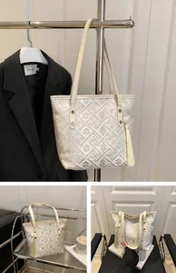 Detail of beige tote bag showing intricate geometric embroidery and elegant tassel charm