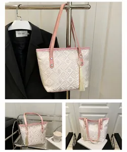 Detailed macro view of pink floral jacquard tote bag with stylish fringe tassel pendant