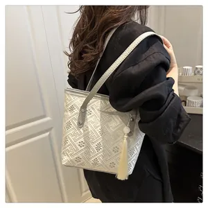 Detail of the chic embroidered tote bag with geometric floral patterns and beaded tassel