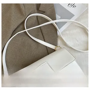 Detail view of the soft white leather shoulder strap and golden metal buckle of the square bag