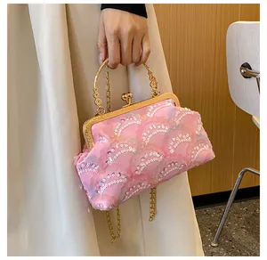 Dettaglio borsa da sera rosa con paillettes bianche e manici in metallo dorato
