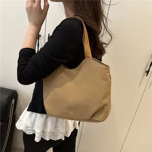 Minimalist khaki canvas tote bag for women showing casual shoulder strap and fabric texture