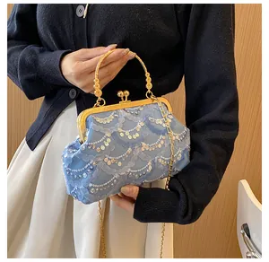 Dettaglio della borsa da sera azzurra con paillettes, pizzo e manico in oro traforato