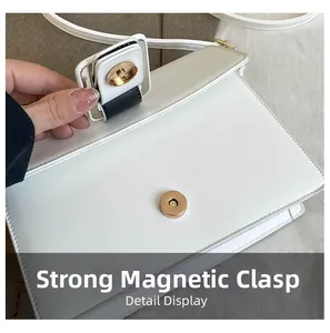 Macro detail of the strong magnetic closure and fine stitching on a white PU leather bag