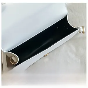 Interior detail of the white leather handbag with black lining and gold hardware