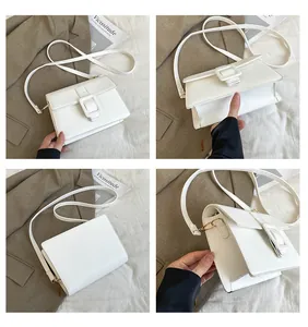 Detail view of white faux leather square crossbody bag with large decorative buckle accent