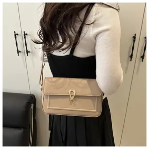 Détail du sac à bandoulière en cuir abricot texturé avec fermoir en métal doré en fer