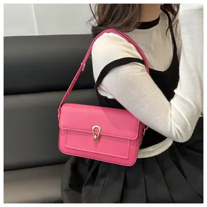 Détail du sac en cuir grainé rose avec boucle en métal doré et bandoulière