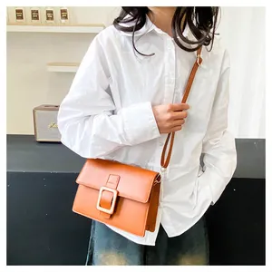 Caramel brown small square bag with gold buckle worn on model with white shirt and jeans