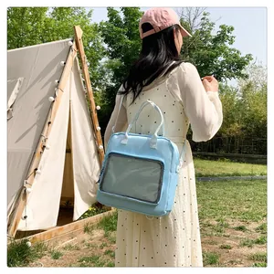 Outdoor lifestyle shot of a light blue large capacity clear backpack with mesh pocket