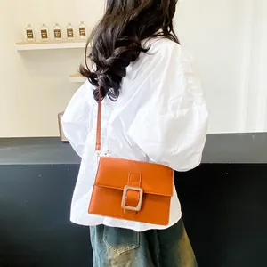 Minimalist orange square leather crossbody bag with large metallic buckle detail
