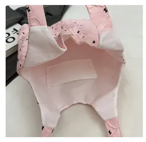 Detailed interior of pink quilted shoulder bag featuring lining and an inner slip pocket