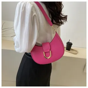 Detail of rose pink crescent hobo bag with gold metal buckle shown on shoulder