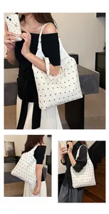 Detailed view of white pleated tote bag with black bow patterns for summer commute