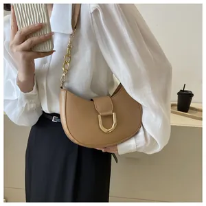 Detail of camel half-moon shoulder bag with gold horseshoe buckle and chain strap