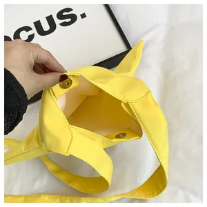 Close-up of bright yellow canvas bag showing interior space and magnetic snap button