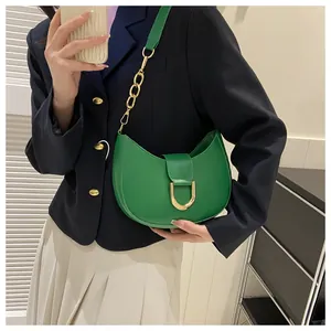 Detail of green leather half-moon bag with gold U-shape buckle and chain shoulder strap
