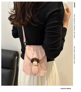 Back view of model wearing a light pink square crossbody bag with wood grain buckle