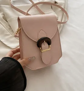 Vue détaillée du petit sac bandoulière rose clair avec boucle aspect bois et finitions dorées