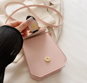 Détail d'un sac bandoulière rose montrant une boucle métallique magnétique sur cuir PU