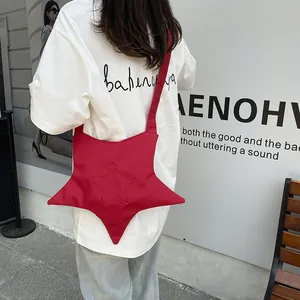 Star-shaped red crossbody canvas bag for women worn by a model in a trendy urban street style