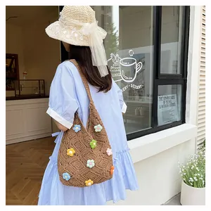 Detail of a brown crochet tote bag with 3D colorful flowers for summer beach vacations