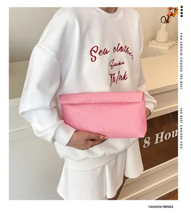 Detail of pink woven texture on a stylish envelope clutch bag with foldable design