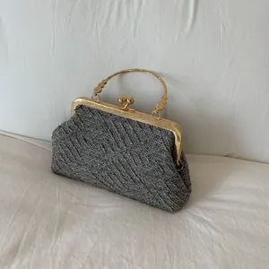Elegant grey woven shell bag with vintage gold metal frame and floral clasp detail