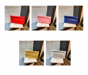 Detail view of woven envelope clutch bags in red, pink, blue, gold, and silver colors