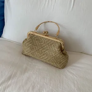 Elegant gold woven evening bag with shell frame, metal handle, and classic kiss-lock closure