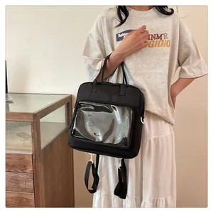 Close-up of clear PVC window and multi-way straps on versatile black canvas ita bag