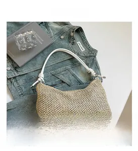 Gros plan détaillé sur la texture tissée crème et la bandoulière nouée du sac
