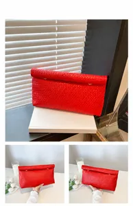 Close-up of a red woven leather clutch bag with a stylish top roll magnetic closure