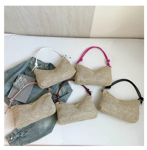 Détail de sacs en paille tissée colorés avec des bandoulières nouées très tendance