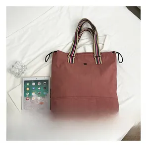 Canvas tote bag size comparison with tablet showing large capacity and striped handles