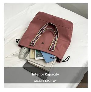 Detail view of pink tote bag showing internal capacity with tablet and books