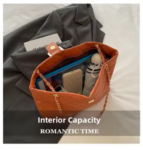 Internal capacity of orange quilted tote bag showing tablet, umbrella, and phone accessories