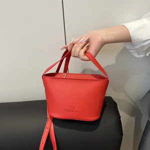 Sac seau rouge en cuir grainé avec poignées et bandoulière réglable
