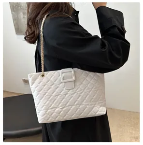 Detail of white quilted chain bag with square buckle and woven gold metal strap
