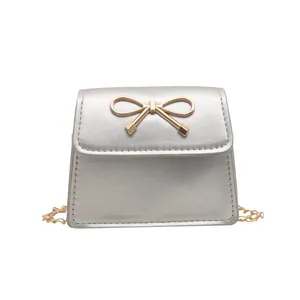 Chic silver mini crossbody bag with golden bow decoration and chain strap
