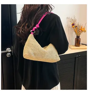 Détail du sac d'épaule en paille tissé main avec une bandoulière en corde rose vif