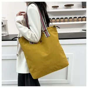 Detailed shot of yellow canvas tote bag with red-white-blue striped strap and drawstring