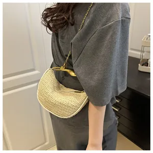 Macro shot of beige woven texture and unique gold irregular handle on crescent bag