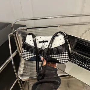 Schwarz-weiße Schultertasche mit Punkten, Schleife und silbernem Herzanhänger-Detail