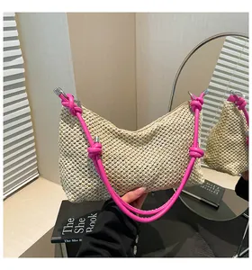 Détail du sac cabas en paille tissée avec bandoulières en cuir rose vif et nœuds