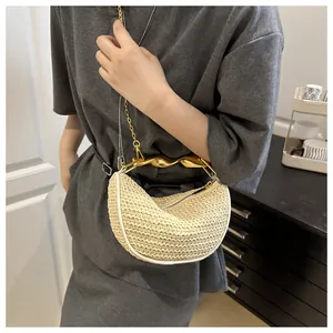 Detail of woven crescent bag with gold twisted metal handle and beige straw texture