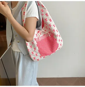 Detail of floral bow tote bag featuring a red gingham pocket and white lace trim detail