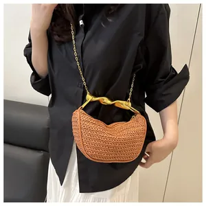 Detail of woven crescent handbag with gold spiral handle and chain strap on model