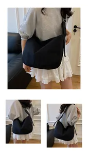 Detail view of large black canvas crossbody bag with adjustable wide strap for daily use