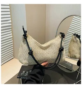 Texture détaillée du sac à bandoulière en paille tressée avec corde noire et anneau